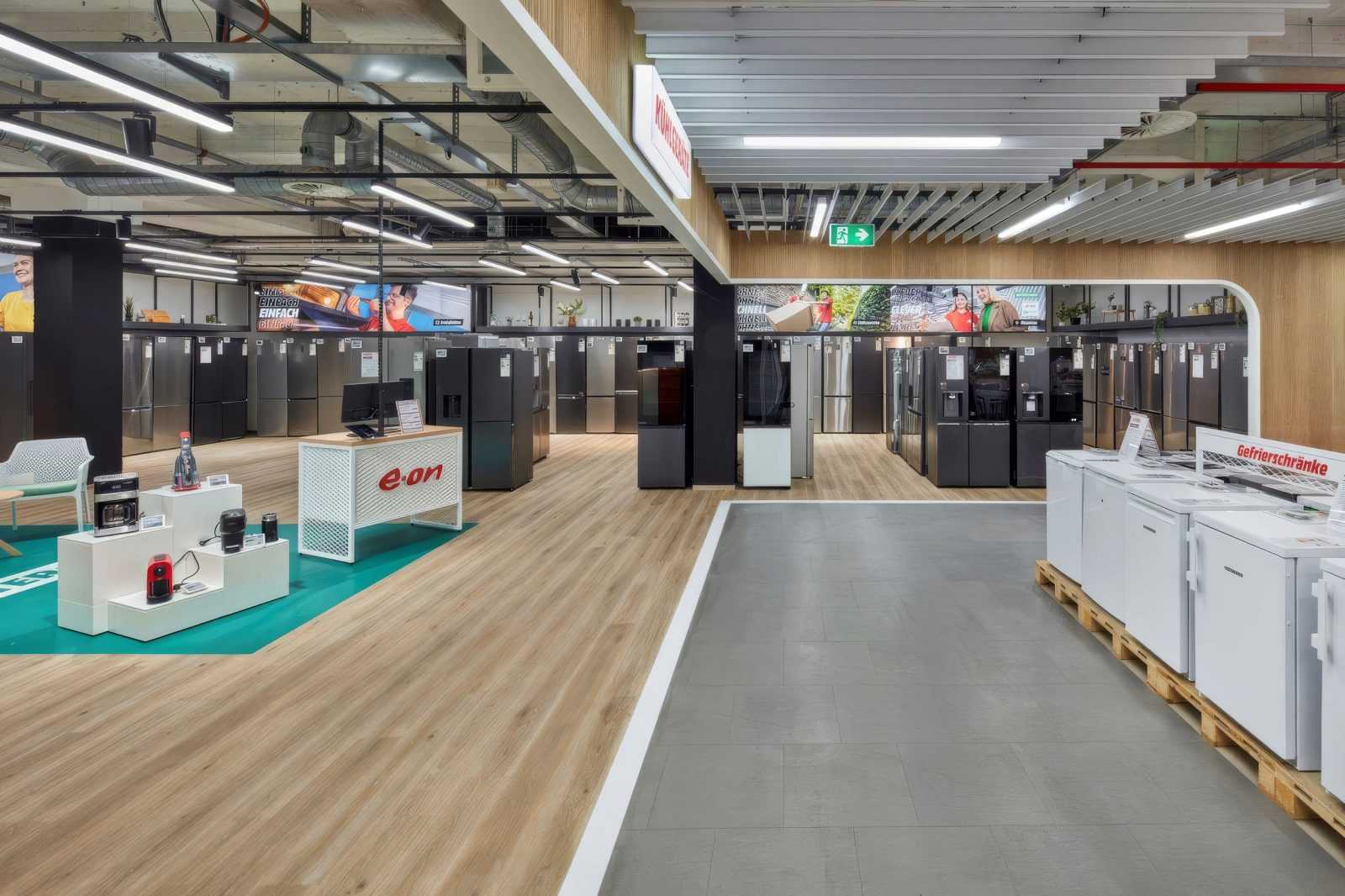 Modern appliance store interior with refrigerators and freezers on display.