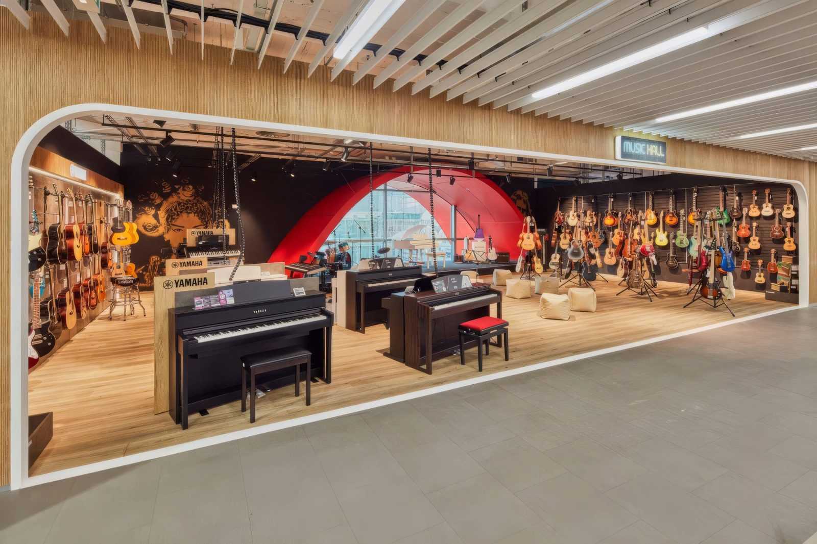 Modern music store interior with Yamaha pianos and guitars on display.