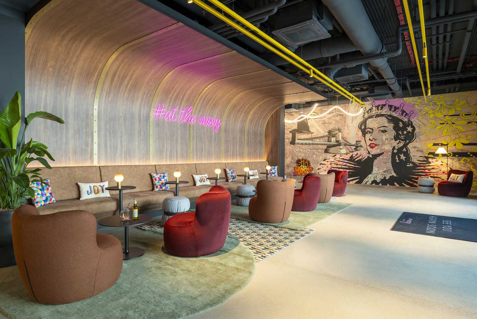 Modern lounge with colorful chairs and vibrant wall art at Megaholz.