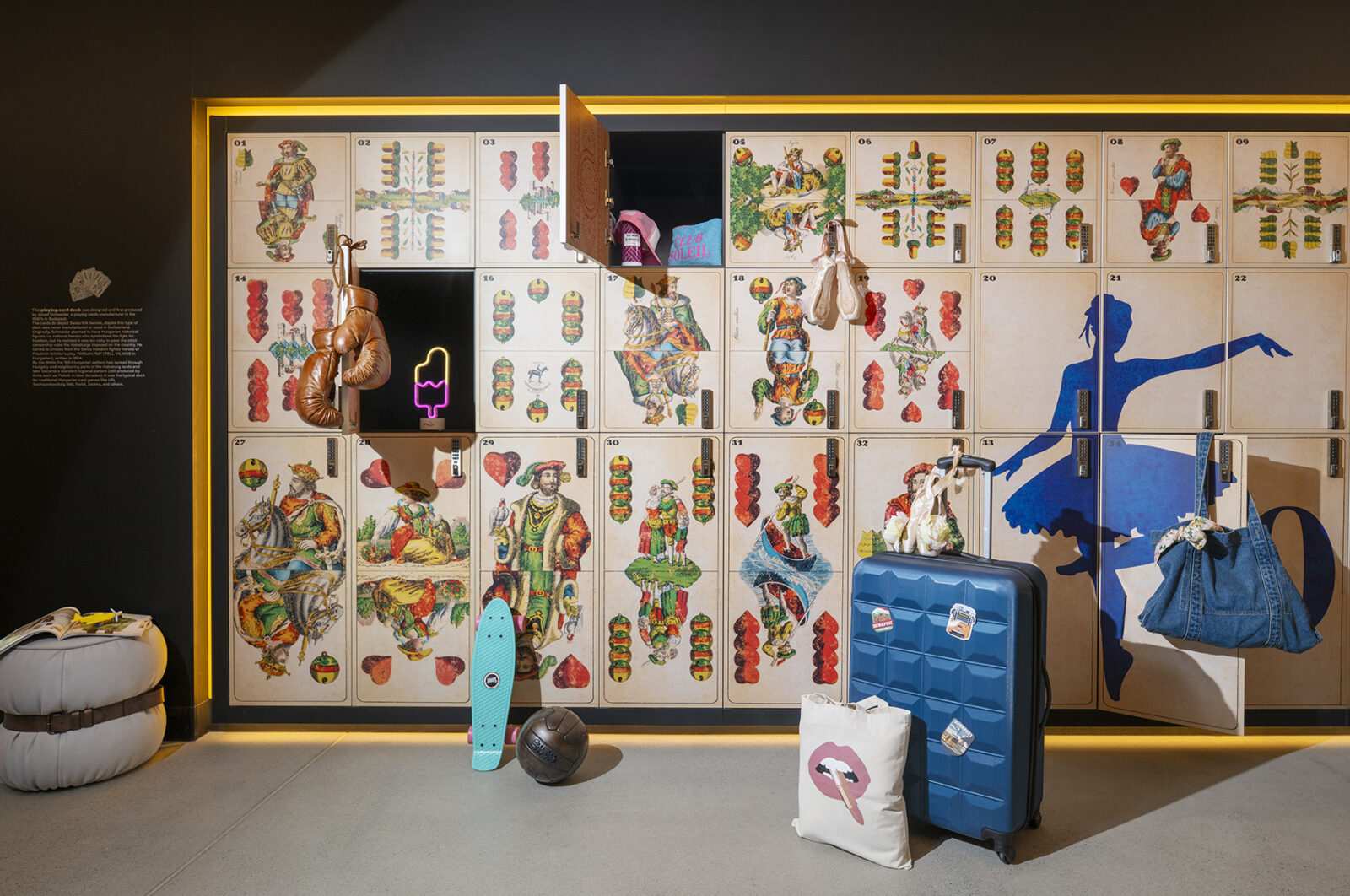 Vintage playing card themed lockers with travel items and neon sign.